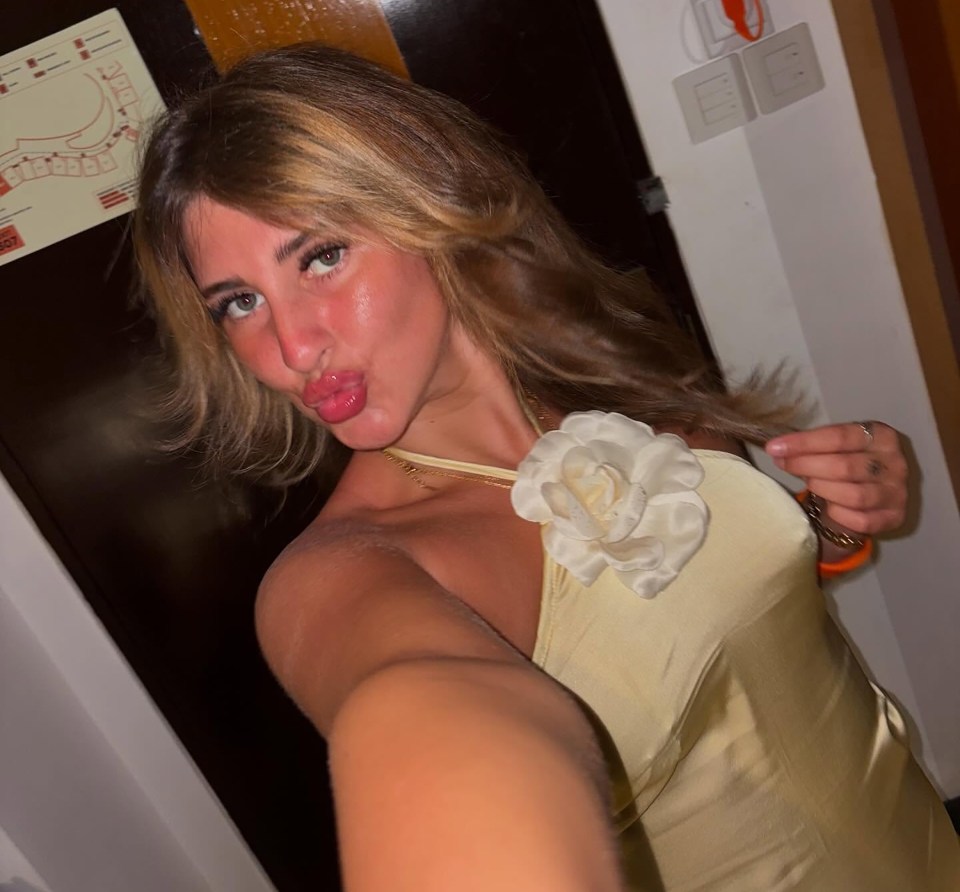 Woman in a pale yellow dress making a kissy face.