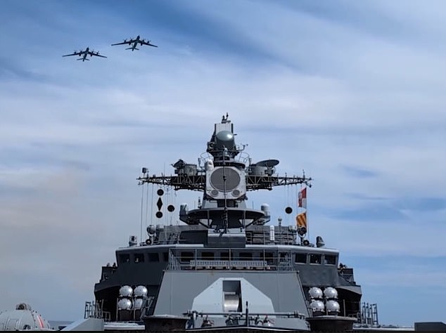 Tu-95 Bear strategic bomber aircraft fly over a Russian warship to open the war games