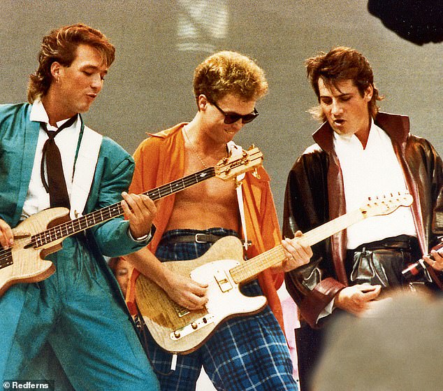 Martin Kemp (left), Gary Kemp (centre) and Tony Hadley (far right) of Spandau Ballet perform on stage at Live Aid, Wembley Stadium, on July 13th, 1985