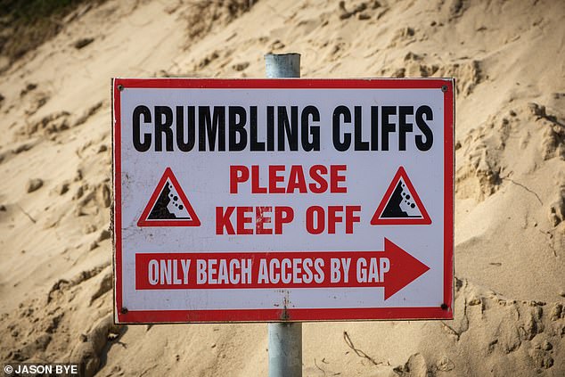 A sign in the area (pictured in May 2024) warns people of 'crumbling cliffs'