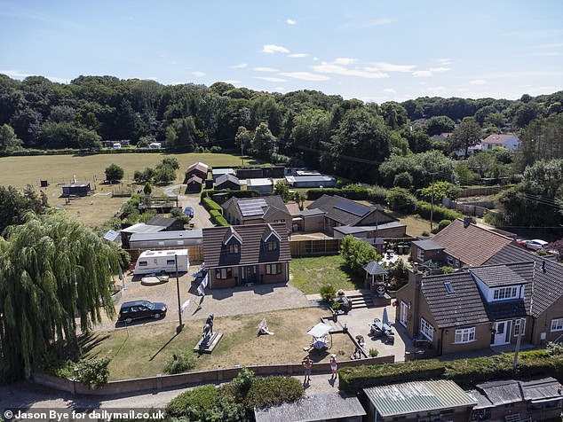 A couple has entered into war with the council after converting their garage (centre) into a two-bedroom home - after being told it is not close enough to the main property (right)