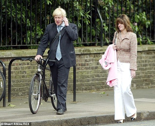 Boris Johnson holding his bike walking next to Petronella Wyatt in London in 2004