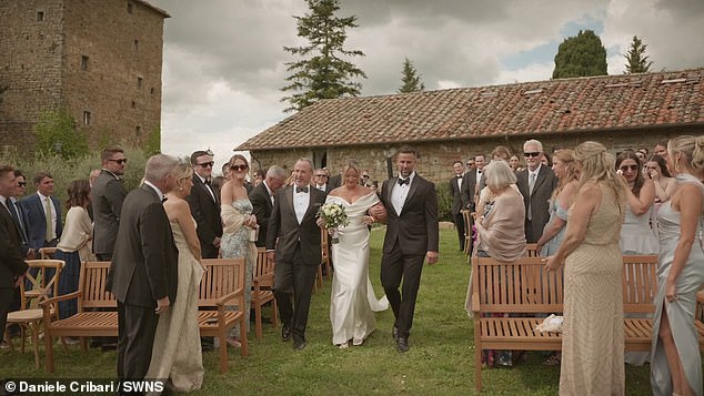 Heart-warming footage captures the moment a bride's father invites her stepfather to walk down the aisle with them