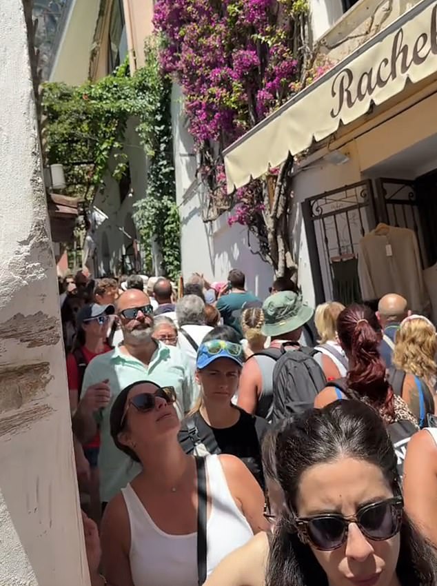 Europe is groaning under a tourism surge, that's overwhelming hotspots and sparking growing backlash from locals. Shocking footage reveal the extent of the crisis, with some streets so crowded that tourists are forced to shuffle shoulder-to-shoulder just to move. Pictured: A street in Positano, Italy
