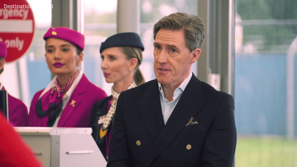 Man speaking to airline staff at an airport.