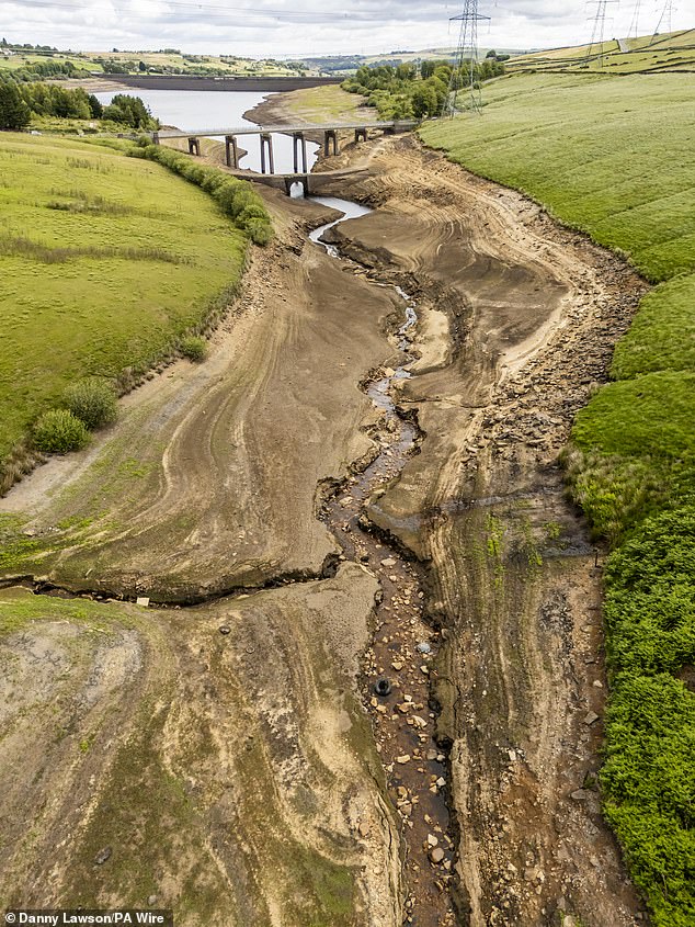 This year's red-hot summer has already seen reservoirs across England run dry, hitting their lowest levels in a decade. Pictured: Dry, cracked earth at Baitings Reservoir in Ripponden, West Yorkshire earlier this week