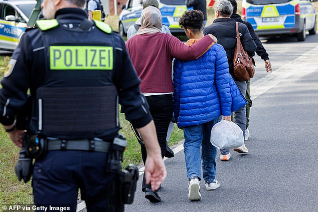Officers of the German Federal Police (Bundespolizei) escort a group of migrants near Forst, eastern Germany on October 11, 2023