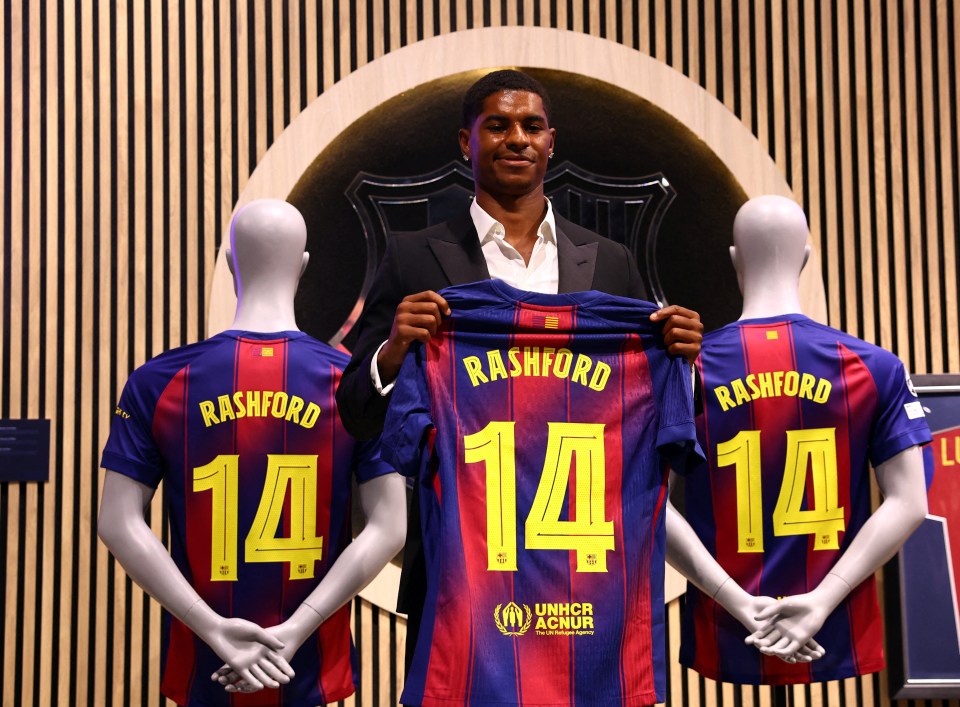 Marcus Rashford holding his new FC Barcelona jersey, number 14.