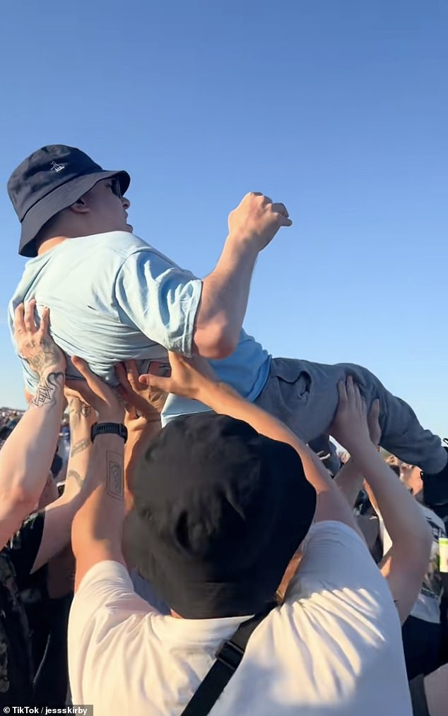 A disabled Oasis fan was lifted into the air so he could see the Gallagher brothers perform on Friday night in a touching display of kindness