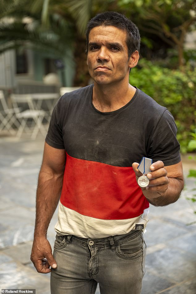 Francisco Garcia claims to have been one of hundreds on a flight from Havana to Moscow after answering an advertisement looking for builders to repair sites damaged by Ukrainian bombardment. Pictured: Francisco brandishing a medal awarded by the Russian army