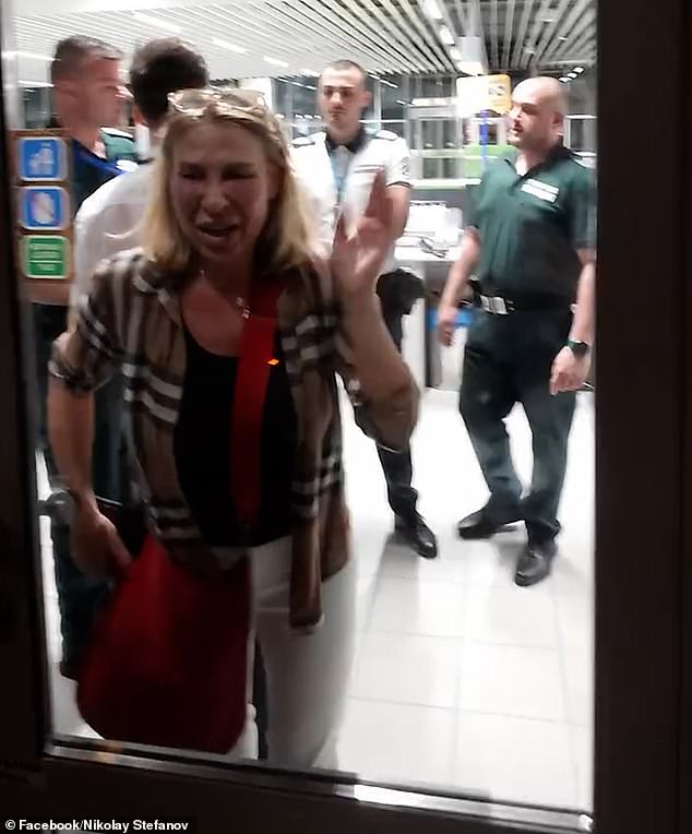 Shocked passengers watched on as the tearful kindergarten teacher hit the doors separating her and the other holidaymakers before being escorted out of the gate