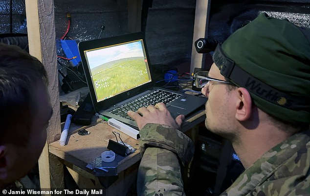 Kus monitors the feed of their drone from the bunker while another soldier controls it
