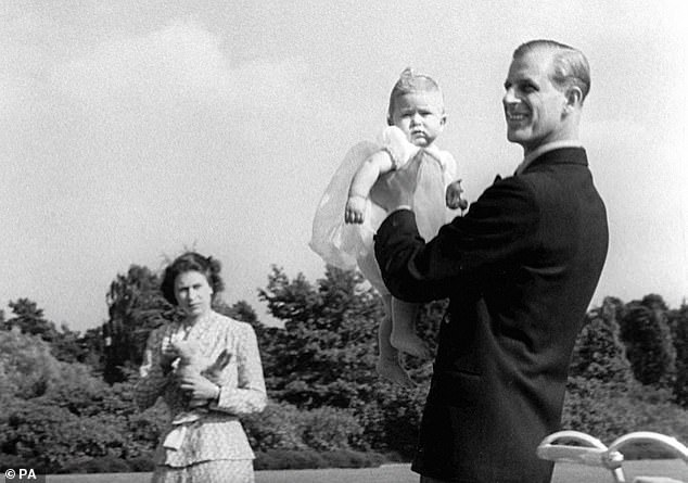 Prince Philip holds Charles in the grounds of Windlesham Moor in 1949