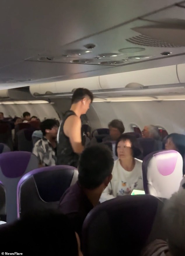 The father of the child can be seen arguing with the elderly passenger, while the woman's friend seated next to her is seen standing up in an attempt to diffuse the fight