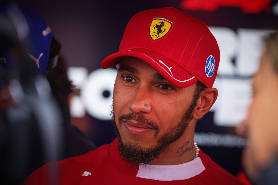 Lewis Hamilton wearing a red Ferrari hat.
