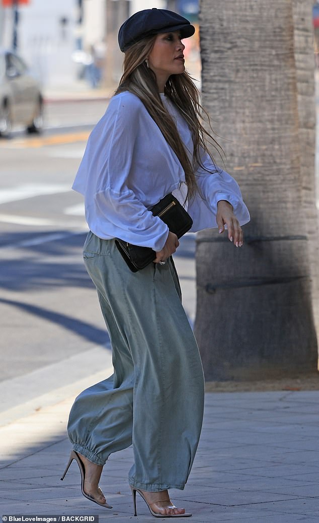 Lopez showed off her sculpted midriff wearing a long-sleeved, white cropped shirt as well as a pair of green trousers