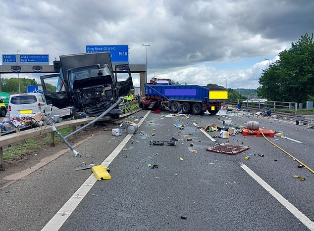 A heavy goods vehicle lies wedged diagonally into the central reservation having crashed into several lampposts
