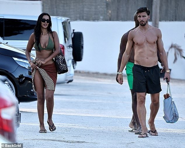 The presenter showed off her curves in a plunging khaki green bikini as she soaked up the sunshine with the Manchester City star at Cala Bassa Beach Club