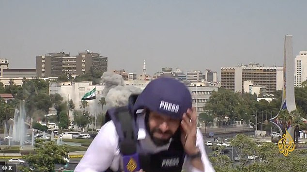 A journalist with Al Jazeera reacts as Israeli strikes hit the Ministry of Defence in Damascus