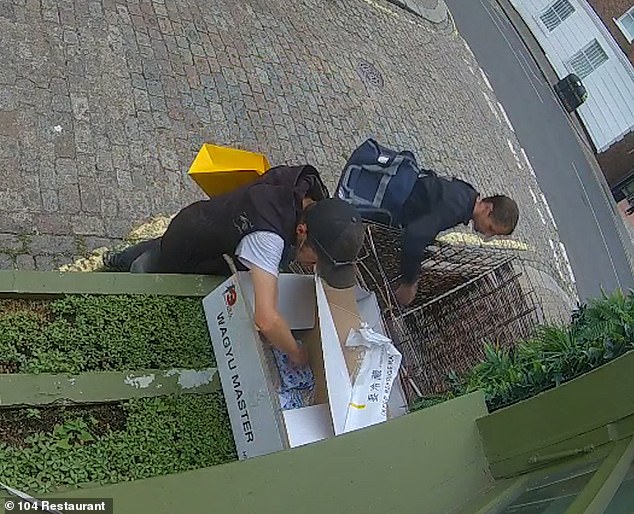 A pair of thieves were seen raking through a delivery that had been dropped off early on Wednesday - while carrying yellow carrier bags from Selfridges