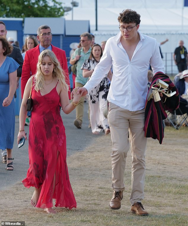 One glamorous woman took off her high heels after standing on them all day as she walked barefooted along the grass