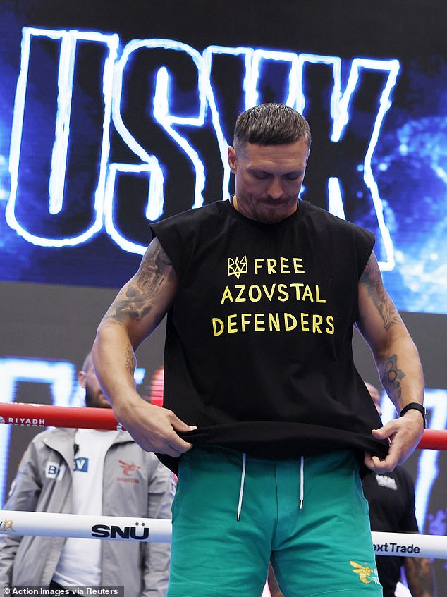 Oleksandr Usyk poses with a shirt showing support for defenders of the Azovstal steel works in Mariupol, Ukraine, as he prepares for his showdown with Daniel Dubois at Wembley