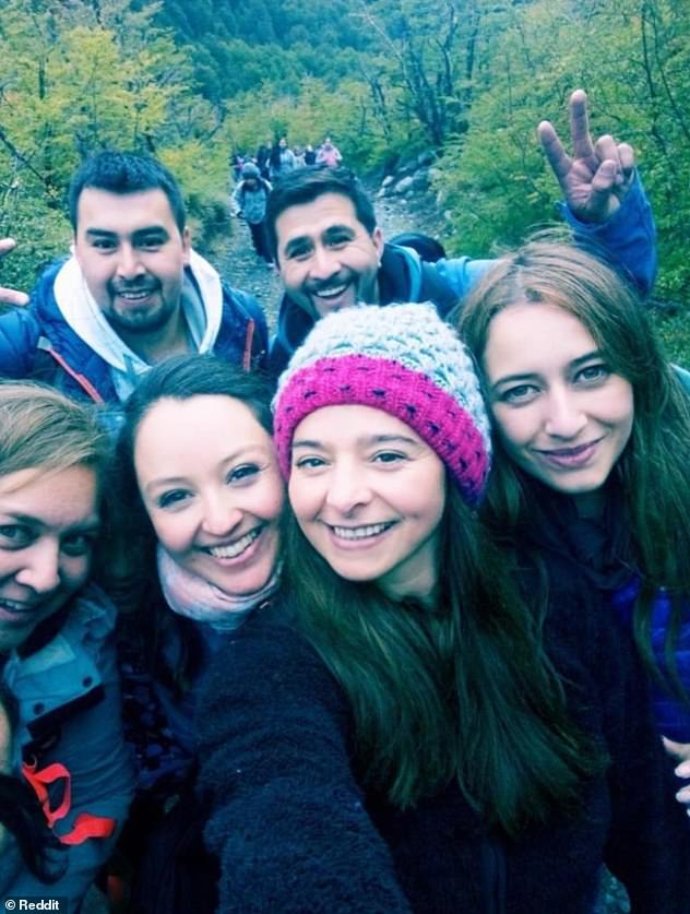 Upon first glance, it may seem as though there are group of six people - four women and two men - who are posing for a selfie while trekking in a forest - but on further inspection, there appears to be a spirit lurking in the picture