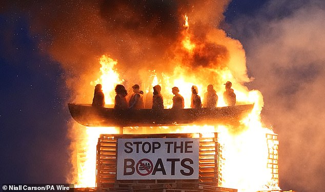 A hate crime probe has been launched after a 'vile' and 'racist' effigy of lifejacket-clad small boat migrants was set ablaze on top of a Northern Ireland bonfire