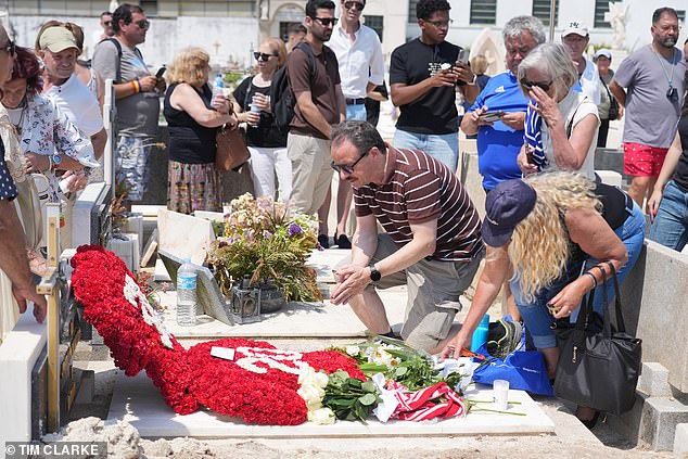 People could be seen crowding around the grave with some crouching down and pointing their phones at the headstone display