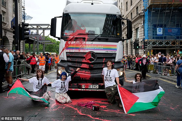 "Youth Demand" activists holding Palestinian flags glue themselves to a truck during the 2025 Pride Parade in London