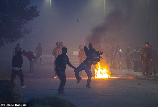 A man was seen throwing projectiles towards police during clashes between migrants and police in Gravelines, France, on Friday