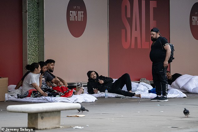 Migrants slept in white duvets on Oxford Street overnight (pictured) after people were evicted from the area last week
