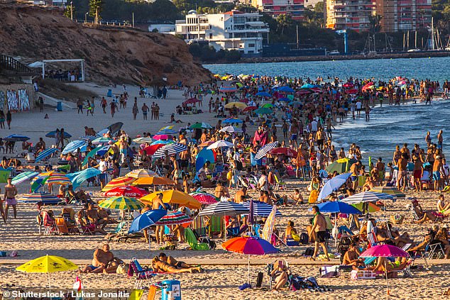 Under the controversial schemes, pupils are having the autumn half term holiday extended from one week to two. Pictured: Families on a Spanish beach