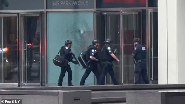 Officers in protective gear were seen entering a building in midtown Manhattan on Monday following reports of an active shooter