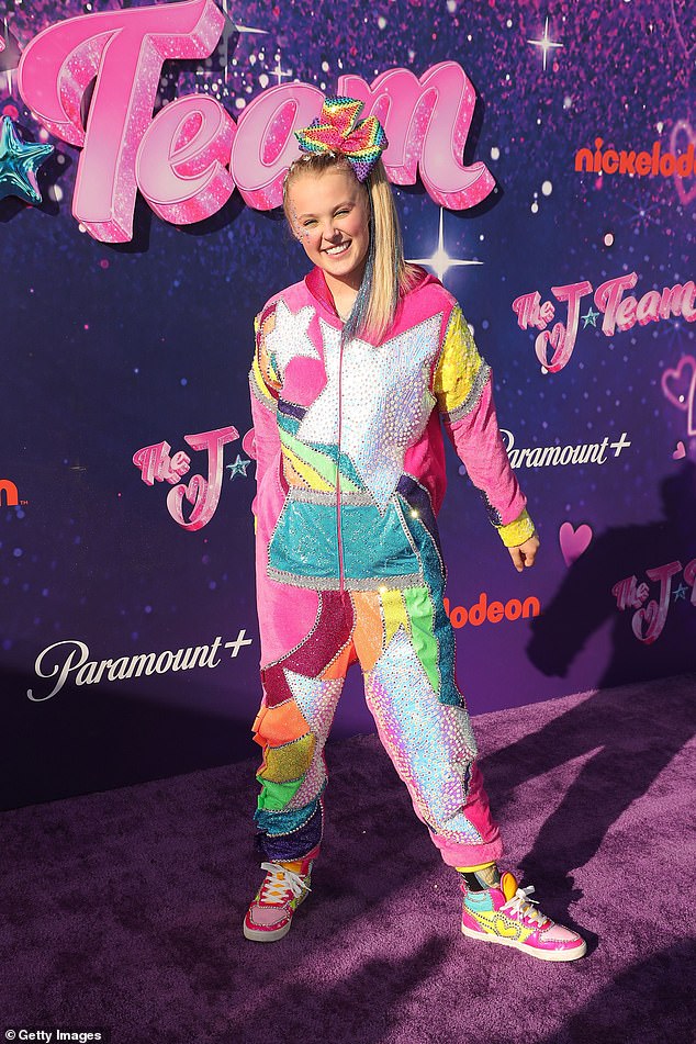 It's JoJo Siwa! The Dance Moms star became famous for her love of bright colours and sparkles, as well as her trademark big bows and high ponytails (seen in 2021)