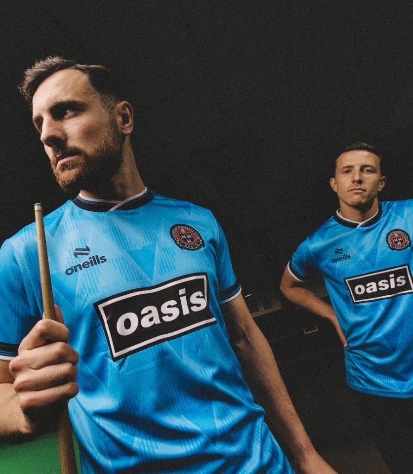 Two men in light blue Oasis-sponsored football jerseys.