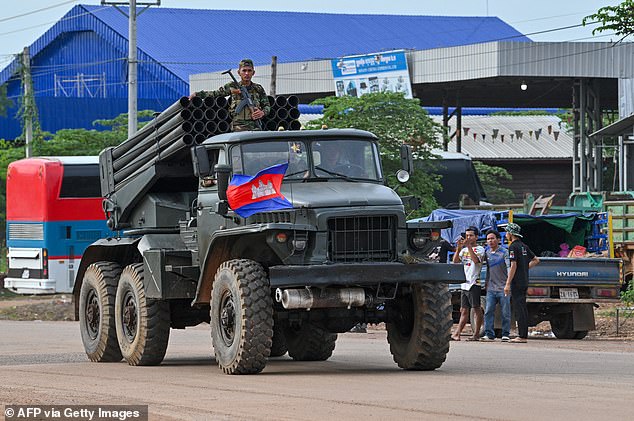 A Cambodian soldier stands on a truck carrying a Russian-made BM-21 rocket launcher travelling along a street in Oddar Meanchey province on July 25, 2025