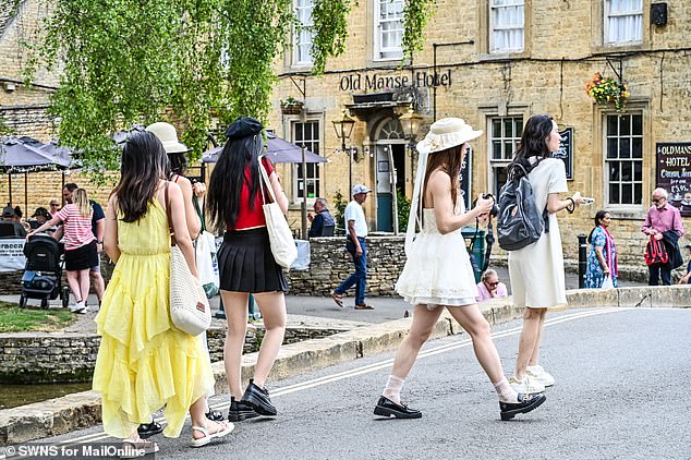 A group of women walk near picturesque buildings in Bourton-on-the-Water this month