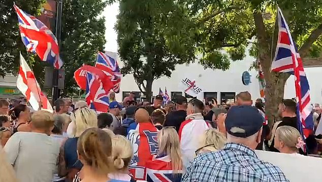 An Epping-style protest to stop migrants being housed above a town's high street shops is underway - as thousands of locals warn of 'mayhem' if the plans go ahead