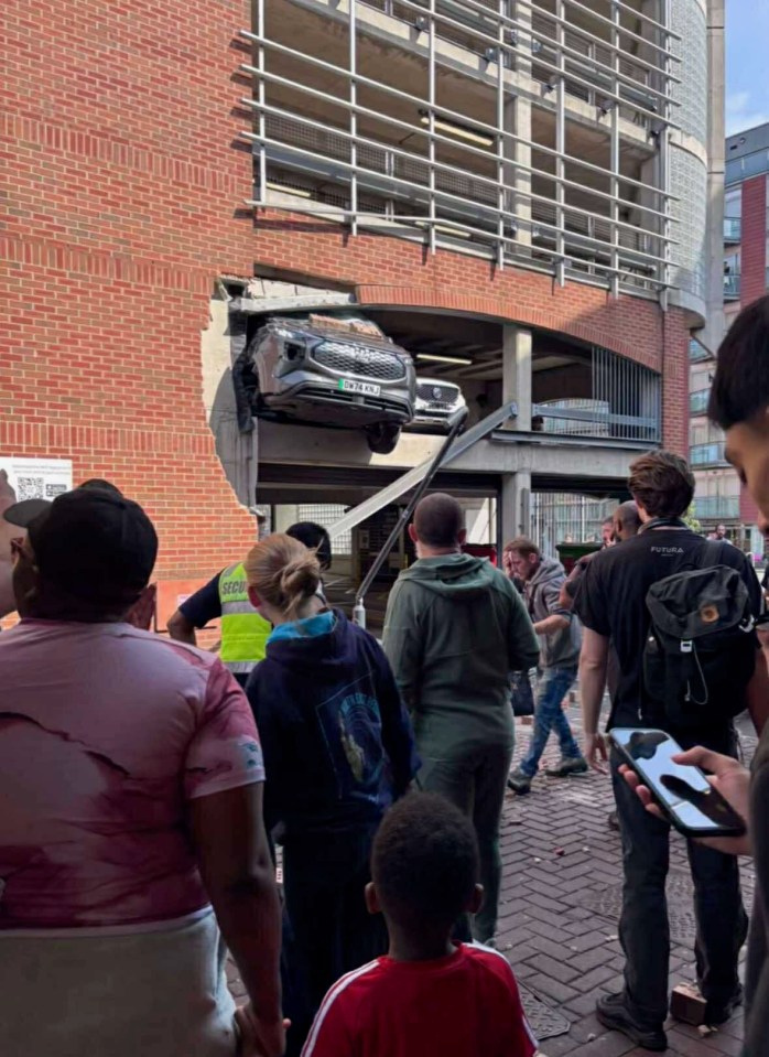 Car crashes through multi-story car park, injuring pedestrians.