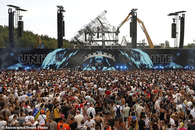Tommorrowland has been hit by a fresh tragedy as a 35-year-old Canadian woman has died, just days after the annual electronic music festival in the Belgian town of Boom was swept by a large festival (Pictured: revelers listen to DJs Odymel and Pegassi performing at the festival on July 18)