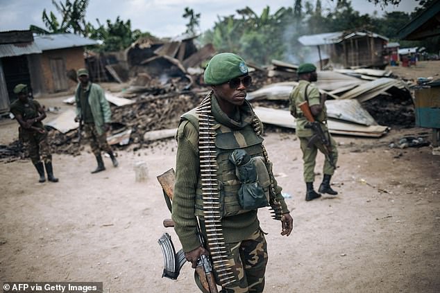 Congolese troops examine a village after an ADF raid in February 2020