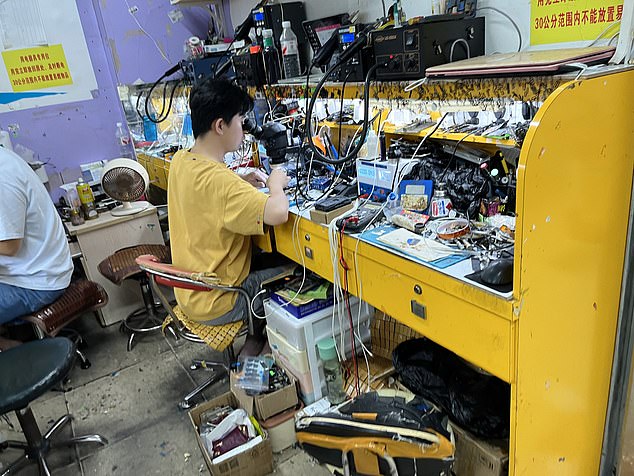 A worker can be seen in a second-hand phone shop in China. Thousands of stolen phones end up in places like these