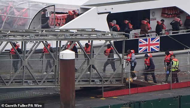 The home secretary is going to usher in 'new laws' to criminalise people traffickers who cram too many 'clients' on to a small boat. Pictured: A group of people thought to be migrants are brought in to Dover, Kent, from a Border Force vessel after a small boat incident in the Channel on July 27, 2025