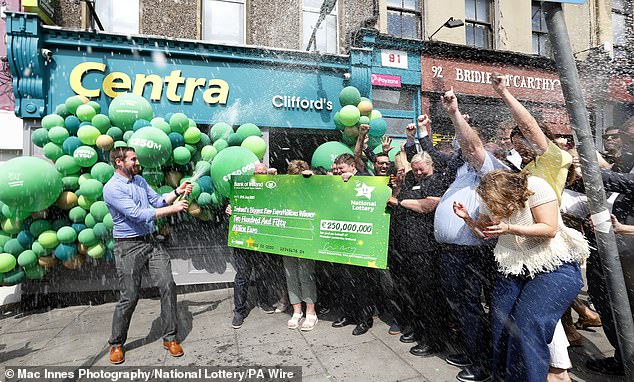 Store manager Simon Champ celebrating with staff from Clifford's Centra on Shandon Street in Cork City centre, which sold the 250 million euro jackpot-winning EuroMillions ticket