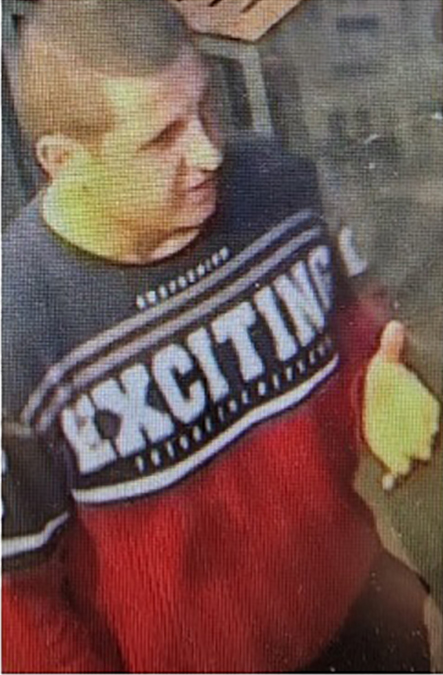Surveillance image of a man wearing a red sweater with "EXCITING" on it.