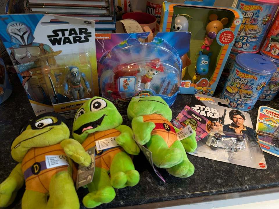 Assortment of children's toys including Star Wars and Teenage Mutant Ninja Turtles merchandise.