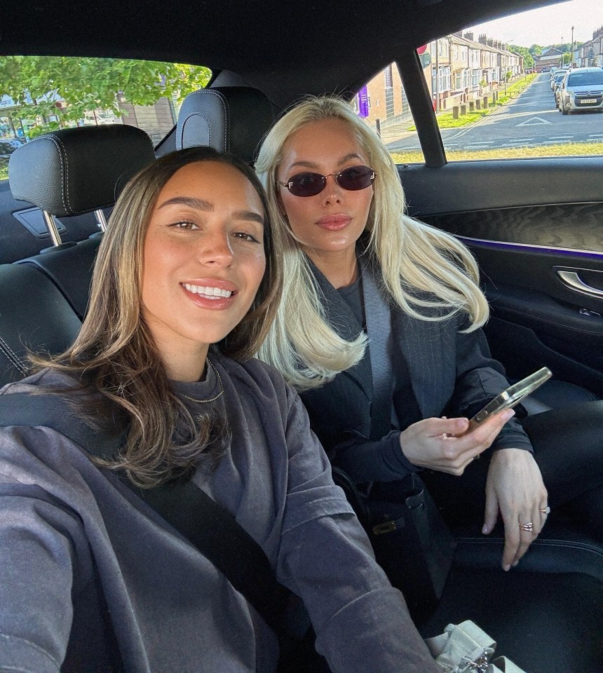 Two women sitting in the backseat of a car.