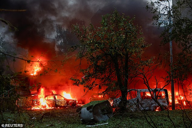 Cars damaged during Russian missile and drone strikes burn, amid Russia's attack on Ukraine, in Kyiv, Ukraine July 31, 2025