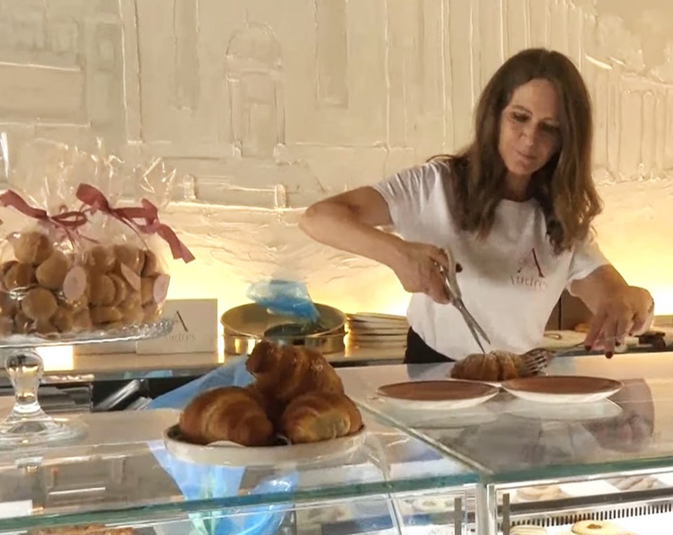Woman cutting a croissant in a bakery.